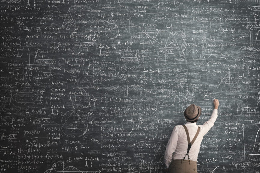 A man stands before a blackboard covered in numerous formulas, representing a scene of intense mathematical study.
