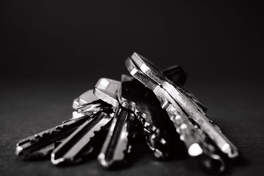 A collection of keys resting on a black surface.