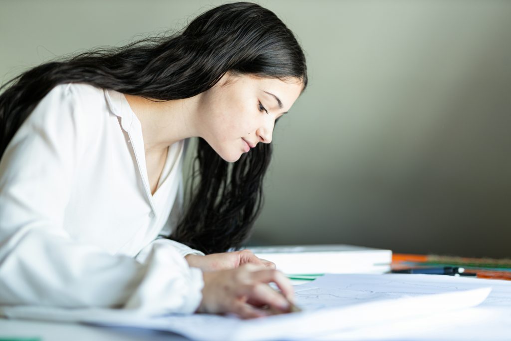 Unraveling the Intricacies of the NIW Application Process a woman writing on a paper