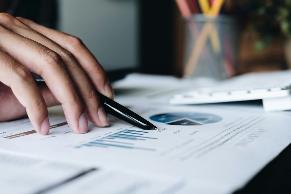 a person holding a pen over a paper
