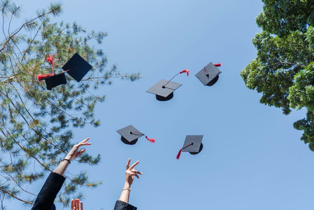 Key EB1 Visa Eligibility Requirements for Immigrating Workers a group of people throwing graduation caps in the air