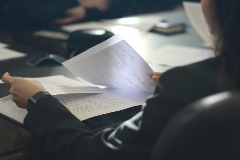 a person holding papers on a table