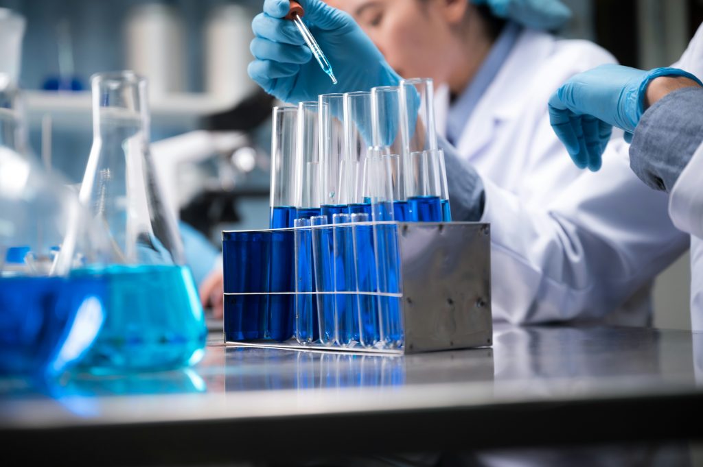 a person holding a dropper into a test tube