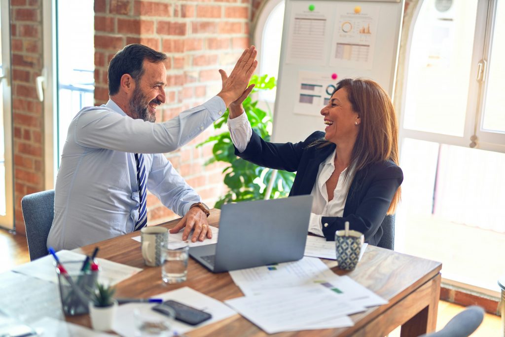 a man and woman giving each other a high five