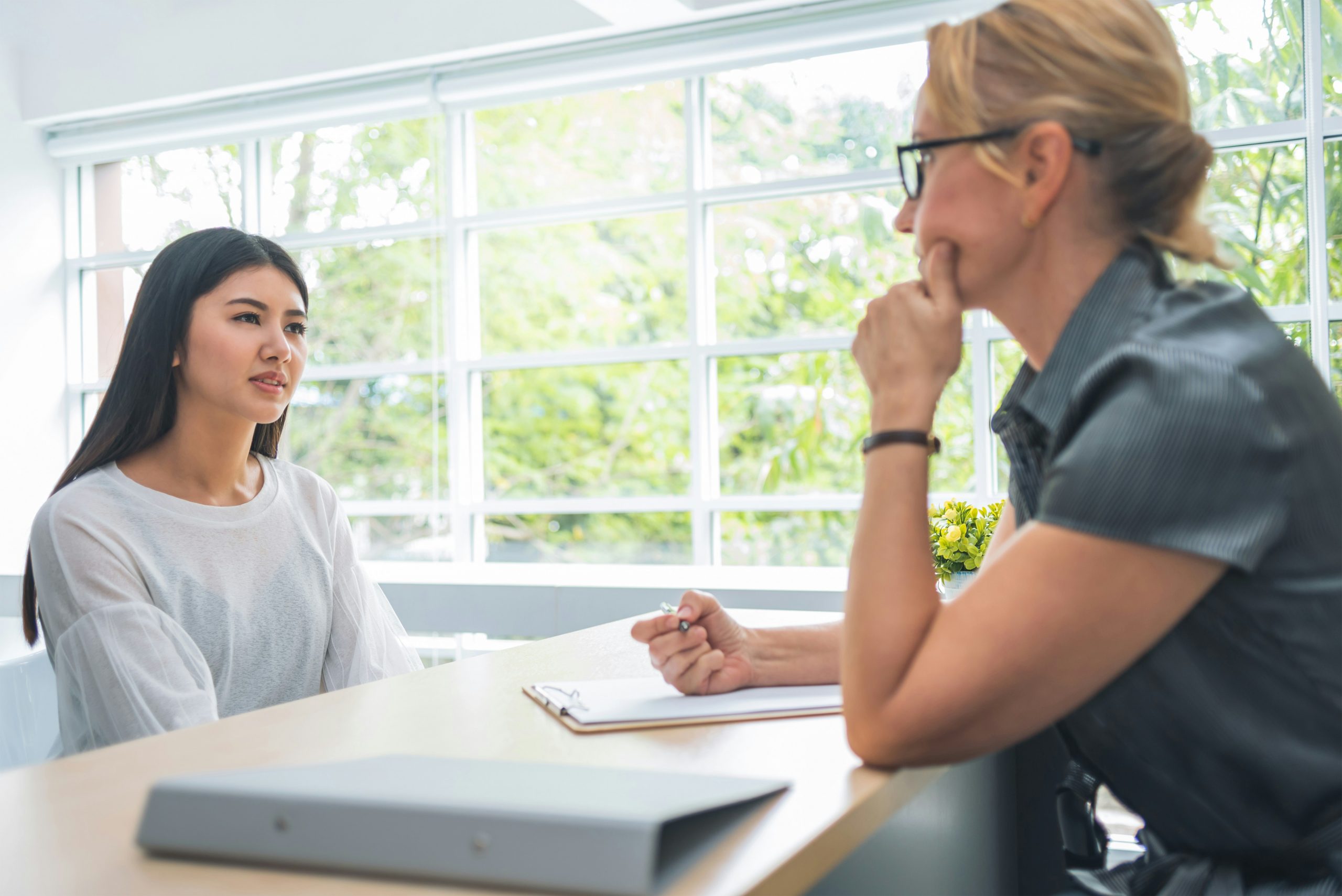 Two women in a conversation indoors.